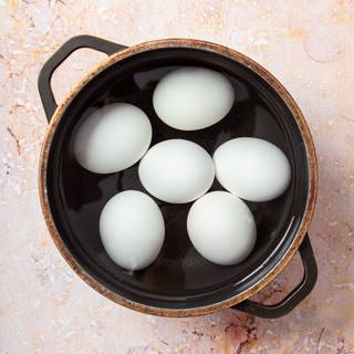 Put the eggs in a medium saucepan and cover them with about an inch of water. Cover the saucepan and bring to a full boil over high heat. Leaving the cover on the pan, remove from the heat, and let stand for 10 minutes. 
