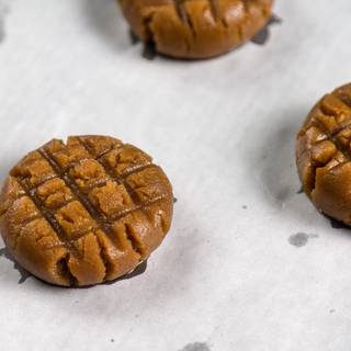 Put some parchment paper on the oven tin and then place one scoop of the batter on it. Make it even and flat by your hand and print some shapes on it with a fork or skewer.