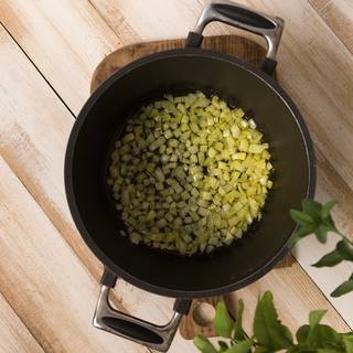 Pour some oil into a pan and fry the chopped onions until they become golden and light.