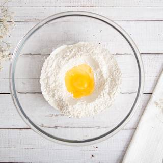 Make a well in the center of the bowl, and then add egg and vanilla.