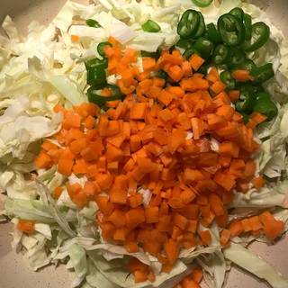 Add the shredded cabbage, chopped carrots and chopped green pepper in another skillet, pour in 1 tablespoon olive oil and saute the mixture over medium heat for about 5 minutes.