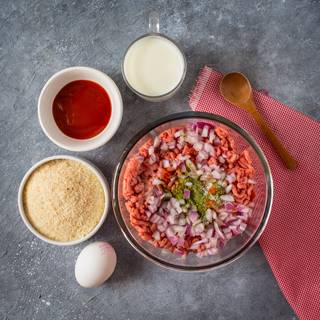 Add diced onion, dried parsley, salt, and pepper to the meat.