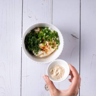 Mix cream cheese, mayonnaise, garlic powder, spring onions, chopped dill, lemon juice, salt, and pepper in a bowl.