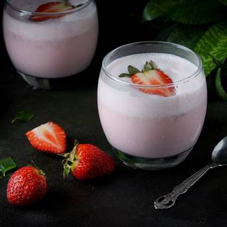 Now, pour your delicious drink into the glass and garnish it with a strawberry.