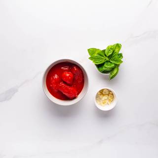 Chop garlic and basil and if you're using fresh tomatoes, peel and puree them in a mixer.