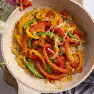 Cut bell peppers like strips and add onion, then sear it for about 15 minutes.