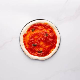 Spread Margherita sauce over the dough. Do not sauce the edges. 