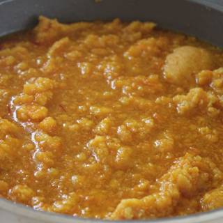 After cooking a little, add the nectar that we have already prepared. Stir it completely, the halva will gain volume and harden. After adding nectar on the heat, fry the halva until it completely absorbs the nectar.