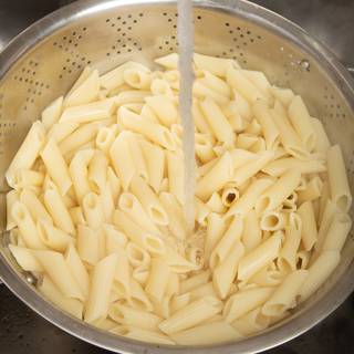 When the pasta is cooked well, drain it and pour cold water to separate them.