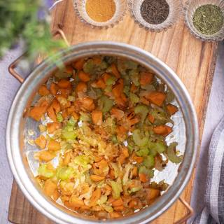 After frying the vegetables, add dried oregano, paprika, and caraway and stir.