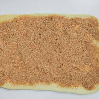 Sprinkle cinnamon and brown sugar on the dough and cover the whole surface.