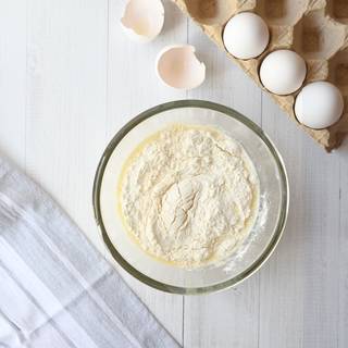 Sift flour and add it gently to the milk and egg until no flour bullets remain. 