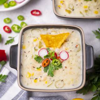 Serve your white bean chili in a proper dish. You can decorate it with parsley, radish, chili, and tortilla.