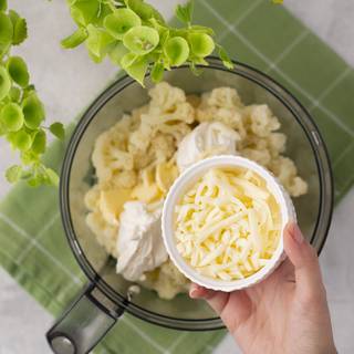 After the cauliflowers are soft, take them off the heat and drain them and let them cool down. Now mix them with cream, mozzarella, 2 tablespoons of butter, and some salt and pepper in a food processor for about 3 to 4 minutes.