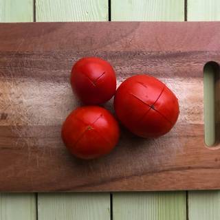 Score the bottom of tomatoes by making an X with a knife. This will make the skin removal easier.