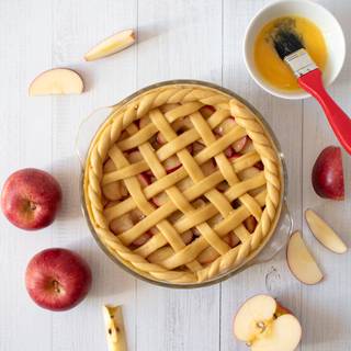 Roll out the rest of the dough and cut it in stripes, put it on the pie, and stick it to the pie crust. cut the extra remaining dough carefully. Beat the yolk and brush the dough, then place the dough on top of the pie in a lattice formation.