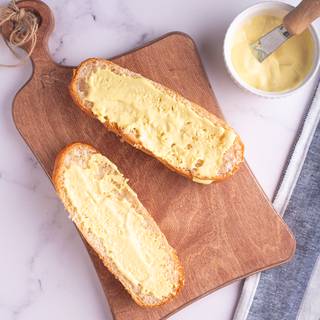 Cut the baguette in half and cover the inside with mustard.