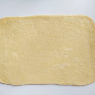 Roll the dough out into a square or a rectangle and spread the softened butter evenly over it.