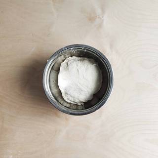 Place the dough into a lidded container and leave it alone at room temperature for about 1 hour to rest. After an hour, divide the dough into 12 pieces. Spread flour over your table and start flattening each dough piece using a rolling pin.