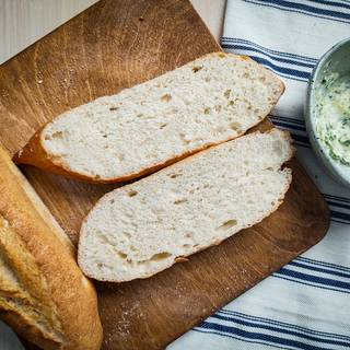 Cut the baguette in half with a sharp knife.