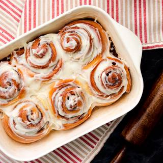 Finally, after the rolls are cool enough, spread the icing evenly over the cinnamon rolls.