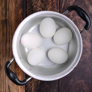 Wash the eggs and put them in water on medium heat until the water comes to a boil.