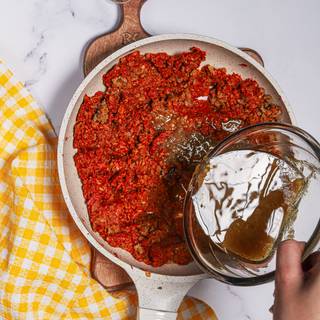 Pour the meat juice into the pan as well and mix it with the beef.