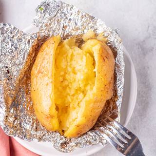 Open the foil and cut the potatoes from the middle and mash and mix the inside with a fork.