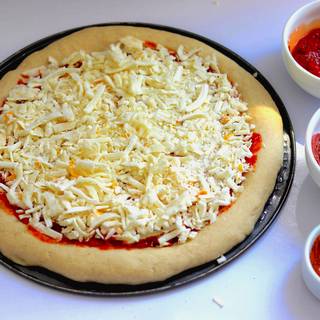 Spread the mozzarella on the surface of the dough, except on the margin, so that it completely covers the dough.