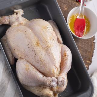 After trussing your chicken, use a brush to grease it with butter.