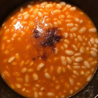 Add the tomato paste mixture and chili powder into the cooked beans and season them with salt and pepper.