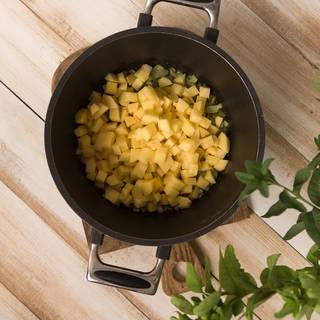 Now add the potatoes and 1/5 liter of vegetable juice into the pan and wait until it comes to a boil. Lower the heat and let the potato pieces become soft.