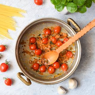 Add the tomato paste to your pan and fry them until the mixture becomes bright red. Cut the tomatoes in half and add them to the onions and let them cook until they are soft.