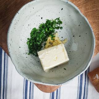 Take the butter out of the fridge to become room temperature. chop the parsley. peel the garlic and crush them.