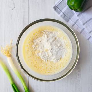 Sift flour and add it to the batter slowly and whisk until they are combined well. Add 2 tablespoons of melted butter or vegetable oil and mix them as well.