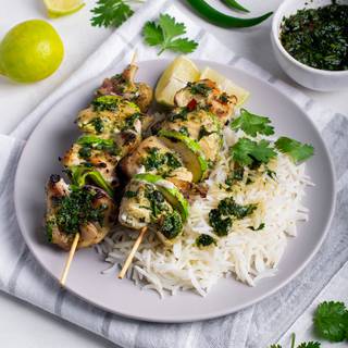 The grilled chimichurri chicken skewers are ready. Pour the rest of the sauce on the kebab and serve with the cooked rice and enjoy.