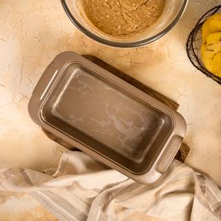 Cover your loaf tin with some parchment paper. Grease the walls of the tin with some butter.