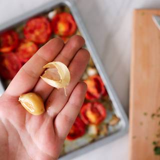 You can easily remove the garlic skin after taking everything out of the oven.