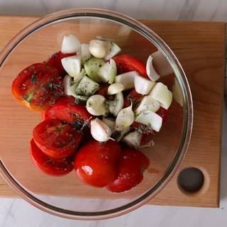 Cut the tomatoes in half and chop the onions. Mix tomatoes onions and garlic in a bowl and add salt, pepper, olive oil, and oregano to the mixture.