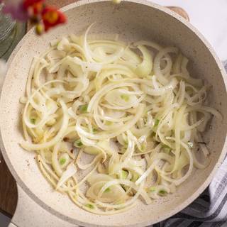 Now, cut the onions into strips way and sear them for about 5 minutes till soft.