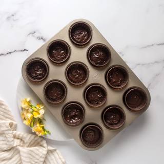 Put the cupcake capsules inside the cupcake tin and fill 2/3 of the capsules with your dough.