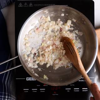 Peel and crush the garlic and add it to the sautéing onion. 