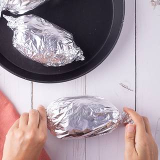 Cover the potatoes with foil, twist both sides, and cook inside the oven at 200C for 1.5 hours. Turn them every half an hour. Check them after one hour to make sure they are cooked well.