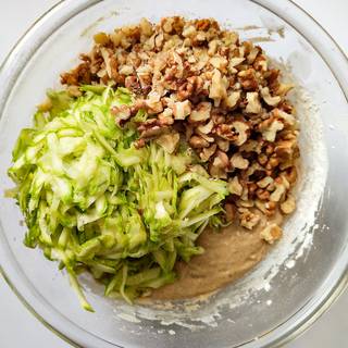 Grate the zucchini and chop the walnuts, then mix it with the batter.