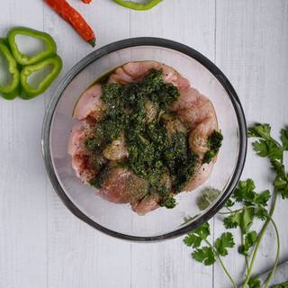 Add two-thirds of the chimichurri sauce with salt and pepper to the chicken and mix them completely. Cover the chicken with cellophane and keep them inside the fridge for at least one hour until the chicken is marinated.