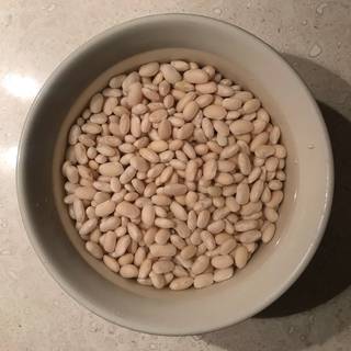 Put the navy beans in a bowl, cover with cold water and let soak overnight.