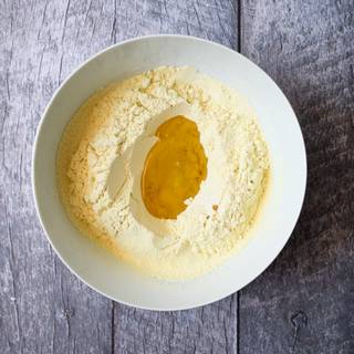 Mix flour with salt and baking powder and sift them at least twice until they are combined well. In a big bowl pour the oil in the middle f the flour and mix them with a spoon.