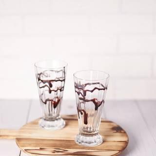 Drizzle chocolate sauce or melted chocolate in a glass along the sides.
