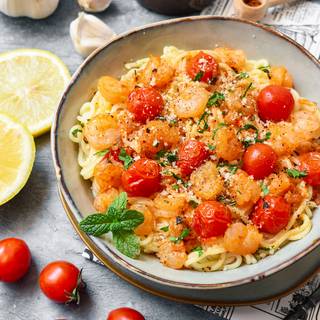 Our spaghetti with shrimps and tomatoes is ready now. You can decorate it with some fresh chopped parsley and parmesan cheese.