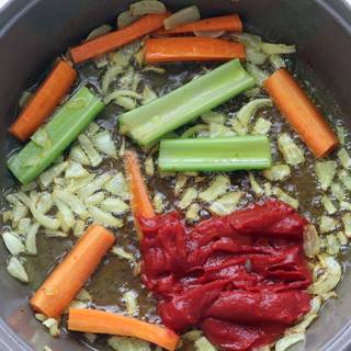 Take chickens out of pan, Cut onions and fry them in same pan for a bit and then add celery and carrots.